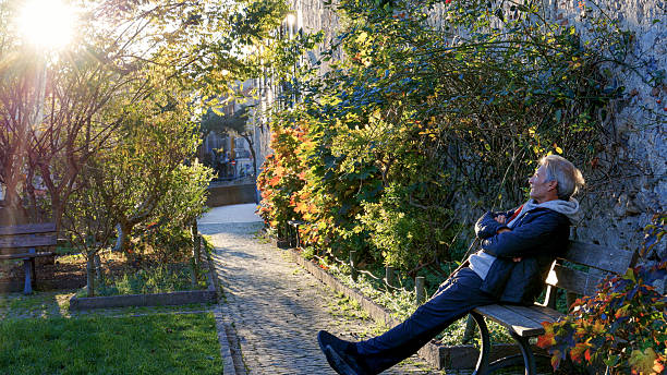 Senior man explores public garden near medieval town at sunrise, Finalborgo
