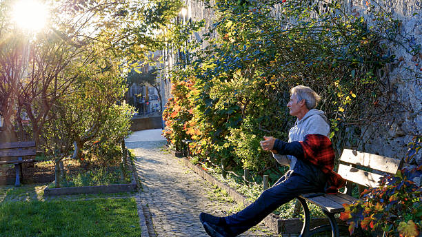 Senior man explores public garden near medieval town at sunrise, Finalborgo
