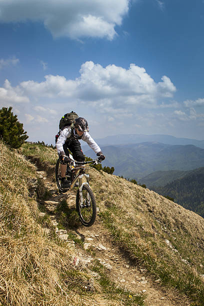 istock Male mountain biker rides down mountain trail 2250169473