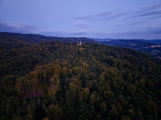 Drone Imagery Showcasing Serenity And Heritage Amidst Mountain Forest And Small Settlement