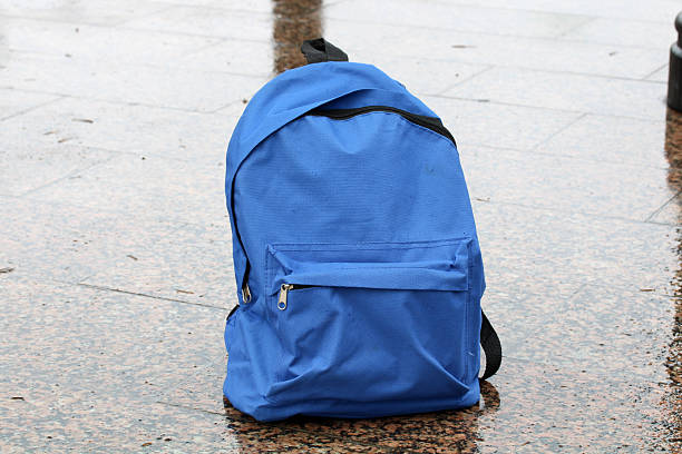 istock Blue backpack abandoned on wet street pavement 2250174682
