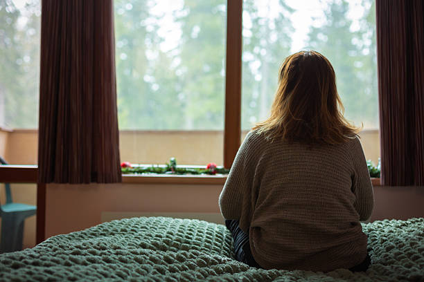 istock Woman looking out window feeling loneliness and sadness 2250175744
