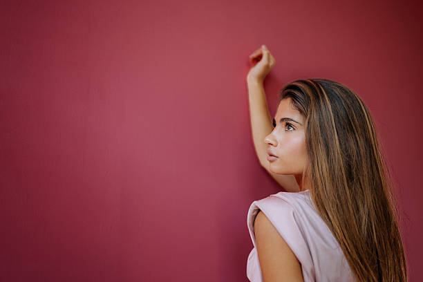 Mature happy woman pointing a wall next to tools to paint