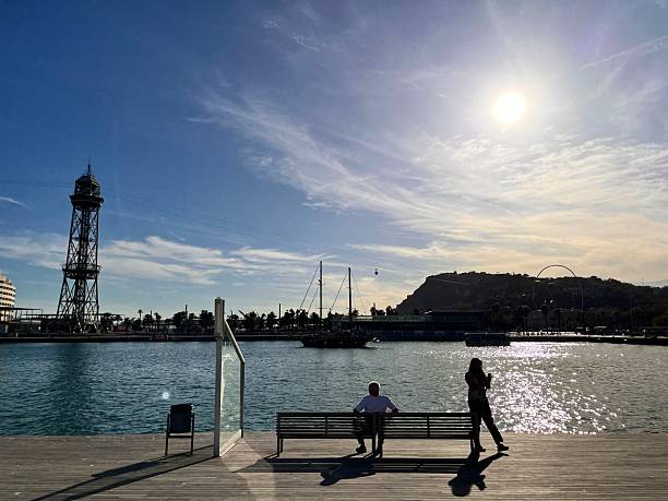 This image offers a tranquil view from a wooden dock, looking out over the still waters of a port.