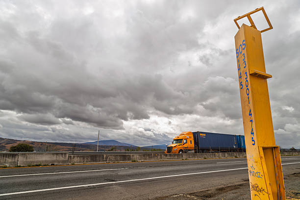 Zapotlanejo, Mexico – January 11, 2025: Freight truck and emergency call box on highway 80D with cloudy sky and hills