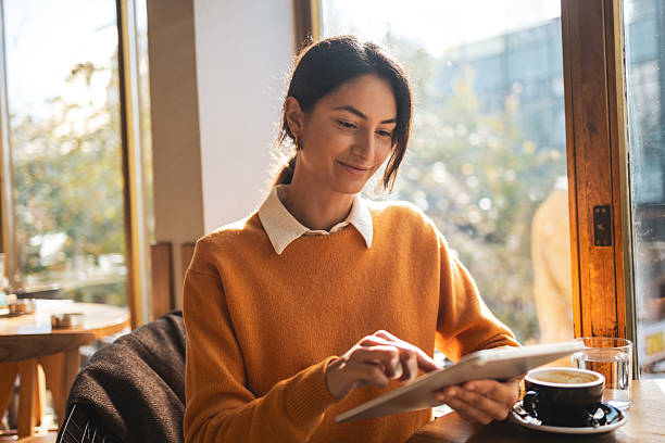 istock Woman working on digital tablet in sunny coffee shop 2250182300