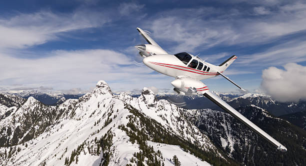 istock Small Airplane Flying Over Snow-Capped Mountains on a Clear Blue Sky Day 2250197254