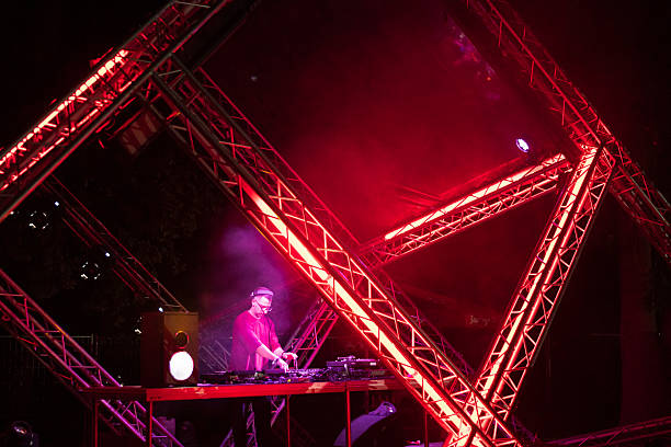 Dj playing techno music on the futuristic stage at the summer music festival.