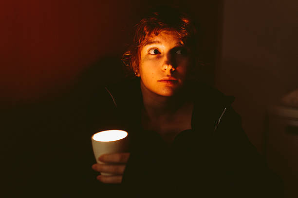 Woman with candle at home because of power cut