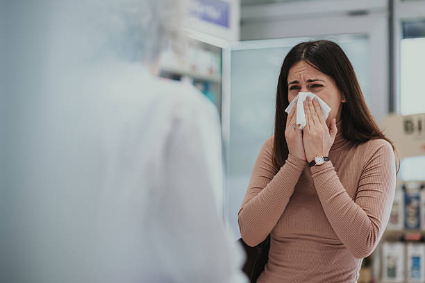istock Woman blowing nose in pharmacy asking for help 2250234593