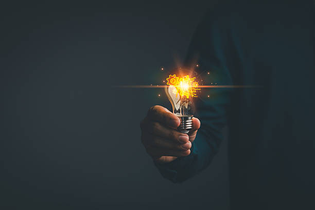istock Business global internet connection application technology. Person holding a glowing light bulb in a dark background, symbolizing creativity, creative solutions, innovation and bright ideas. 2250235999