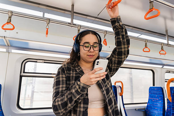 istock Young Woman with Headphones Commuting on Train 2250237609
