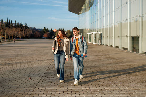 istock Two smiling multiethnic students walking together outside a modern university building 2250244001