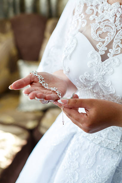 istock bride puts on wedding jewelry on the wedding day 2250246324