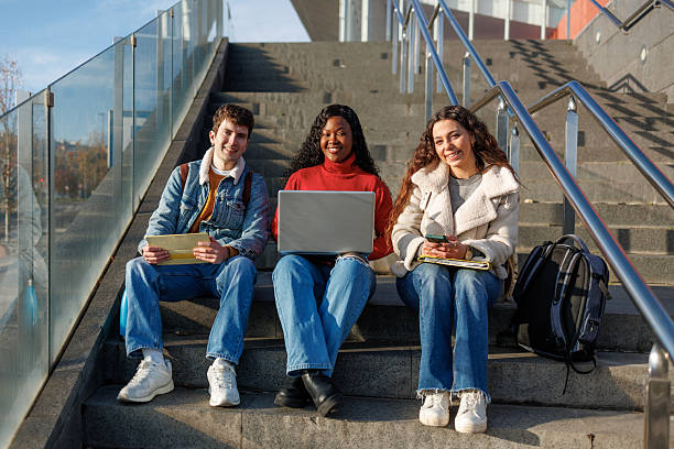 istock Multiethnic university students using laptop and digital tablets on outdoor stairs 2250247038