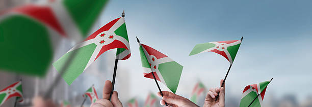 istock Burundi flags in their hands on a blurred urban background 2250255783