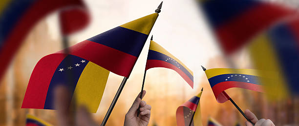istock Venezuela flags in their hands on a blurred urban background 2250256473