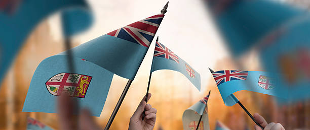 istock Fiji flags in their hands on a blurred urban background 2250256534