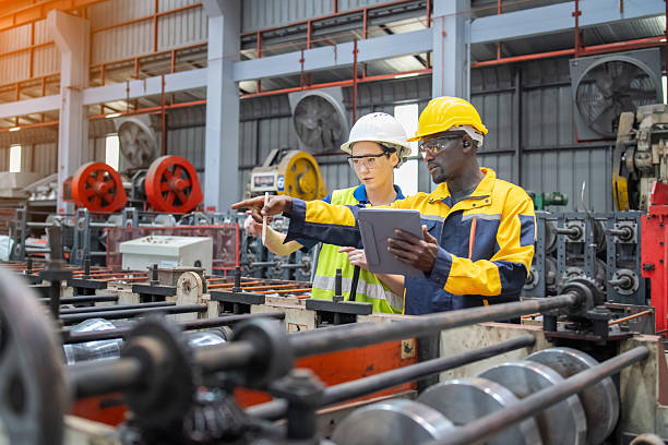 istock Industrial workers inspecting machinery and discussing workflow on a production line. Professional teamwork, safety, and precision in modern manufacturing. 2250259774