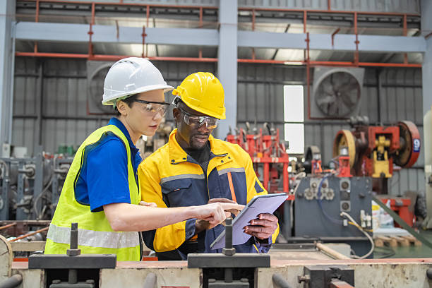 istock Industrial workers inspecting machinery and discussing workflow on a production line. Professional teamwork, safety, and precision in modern manufacturing. 2250259784