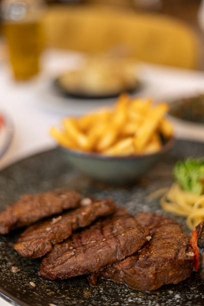 Grilled steak dinner with golden french fries and pasta side dish, a perfectly cooked and seasoned beef fillet meal serving in a restaurant or at home