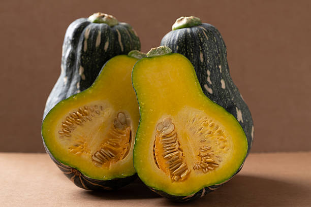 istock Half green butternut squash pumpkin on brown background 2250263568