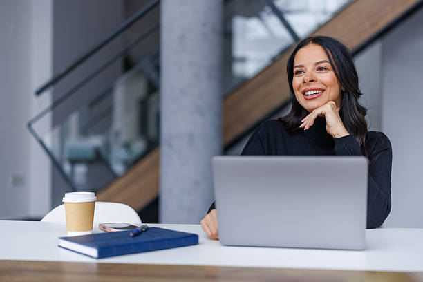 istock Woman working on laptop smiling thinking at desk 2250265651