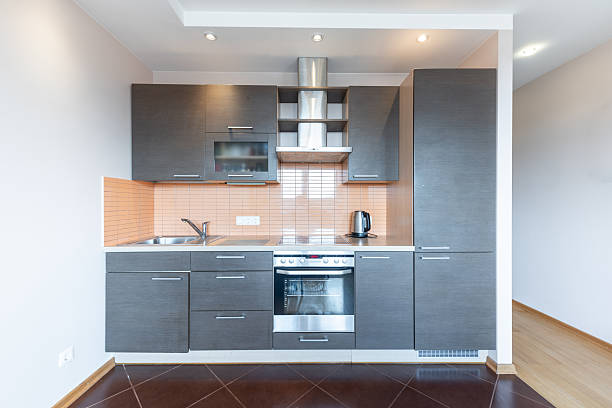 Contemporary and sleek kitchen featuring dark wood cabinets, bright orange backsplash, and modern appliances in a minimalist interior design style.