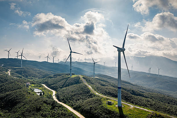 istock Wind turbines and winding road on the mountain ridge with dramatic clouds and sunlight. 2250271762