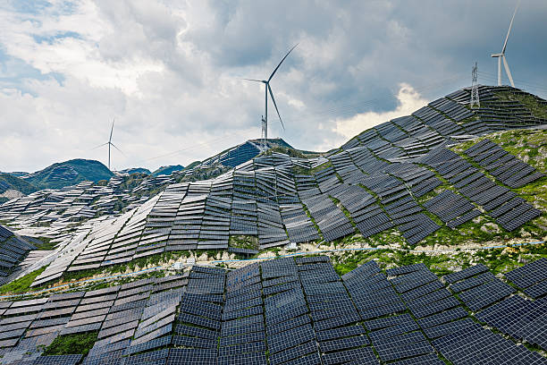 istock Wind turbines and solar panels generating renewable energy on mountain background. 2250272127