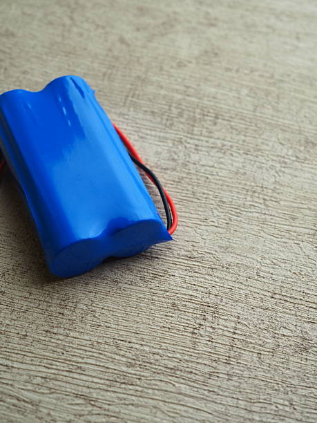 istock Bright blue battery pack with red and black wires rests on a textured light brown surface, conveying a sense of modern simplicity 2250274085