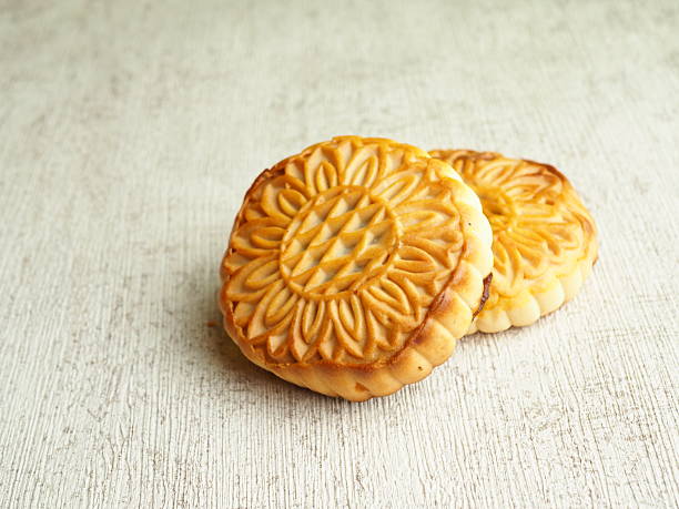 istock Two golden brown baked goods rest gently on a textured surface, featuring delicate floral designs and warm, inviting tones and 2250274584