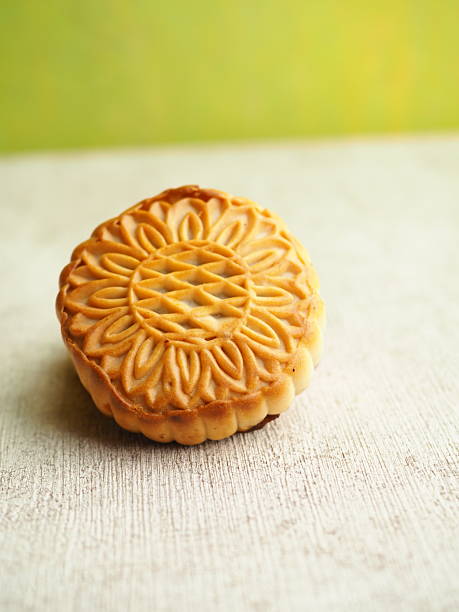 istock Detailed mooncake with intricate floral design sitting on a textured surface with soft lighting. 2250274950