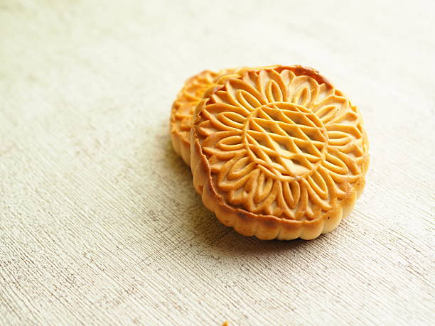 istock Two intricately patterned baked cakes rest on a textured white surface, glowing with warm light. 2250275435