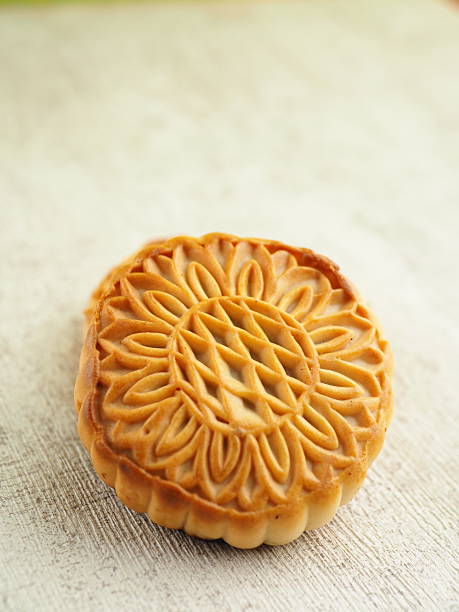 istock Close-up showcases a delicately crafted mooncake on a textured surface in warm, inviting light. 2250275546