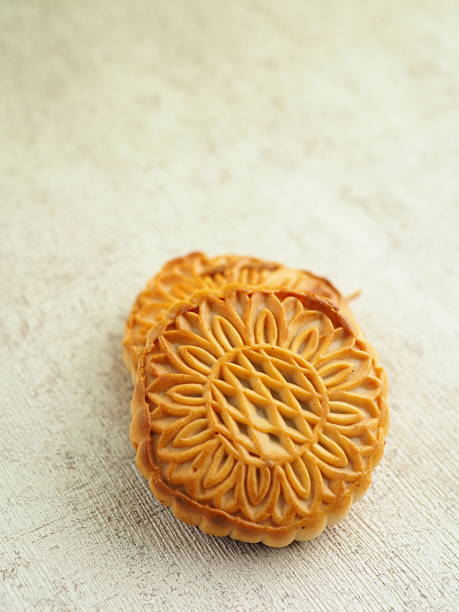 istock Two delicate mooncakes rest on a textured surface, their ornate floral patterns softly highlighted. 2250275557