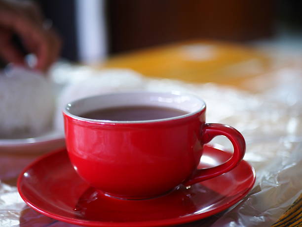 istock A vibrant red teacup filled with warm tea sits elegantly on a matching saucer, inviting relaxation. 2250276528