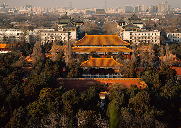 At dusk in winter, the tiles of the Forbidden City are covered with white snow and shining with golden light.