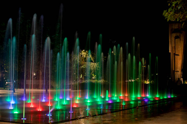 Long-exposure photo of colorful illuminated fountain in Deda Ena Park, Tbilisi, Georgia at night.