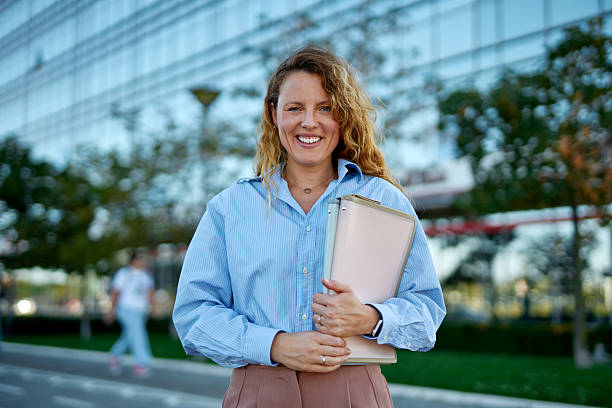 istock Confident business woman standing outdoors holding folders 2250283694