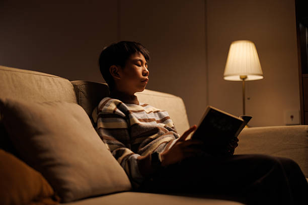 istock boy sits on the sofa at home at night reading a book 2250283969