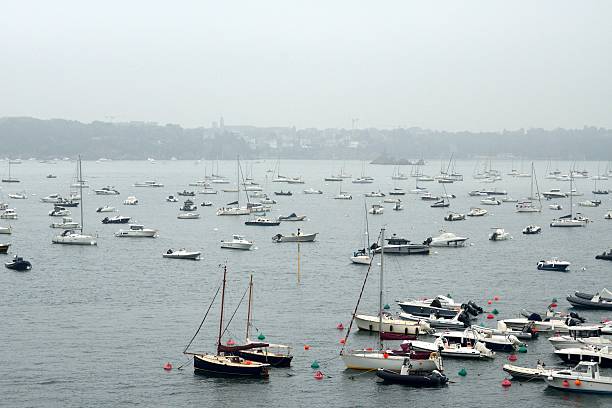 Binic, France - July 21, 2024: View of a marina in Binic filled with various boats and yachts. The water is calm, reflecting the sky and surrounding boats.
