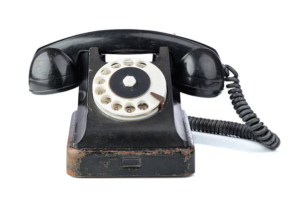 Vintage black phone with rotary dial isolated on a white background.