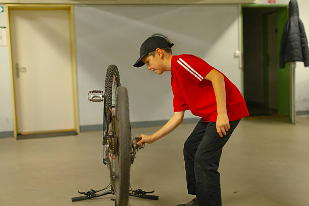 istock Male adolescent calibrates wheel and spoke assembly diligently 2250294207