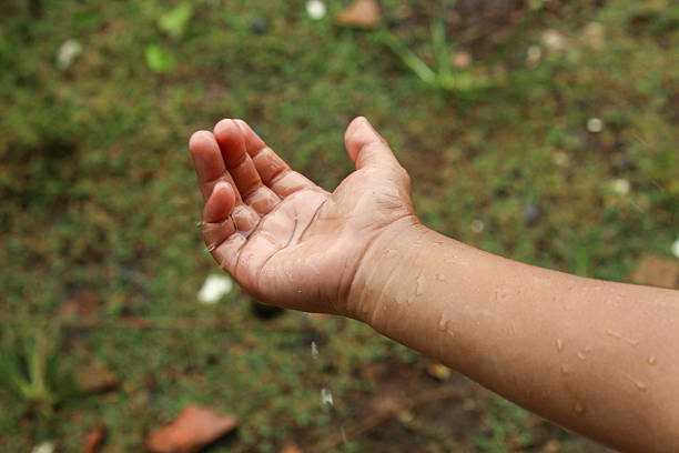 Close up of a child's hand with falling raindrops