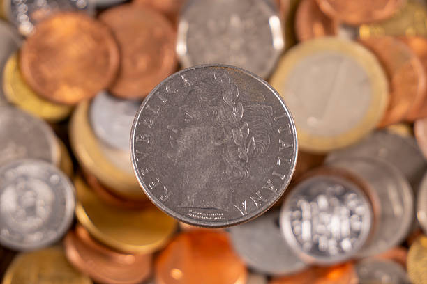 istock Old coins scattered on a surface with focus on a central coin 2250304710