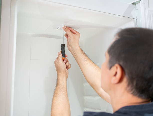 istock Male repairman fixing refrigerator 2250305855