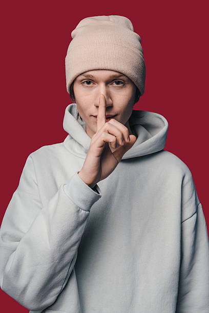 istock Mysterious teenager making silent gesture against background 2250306475