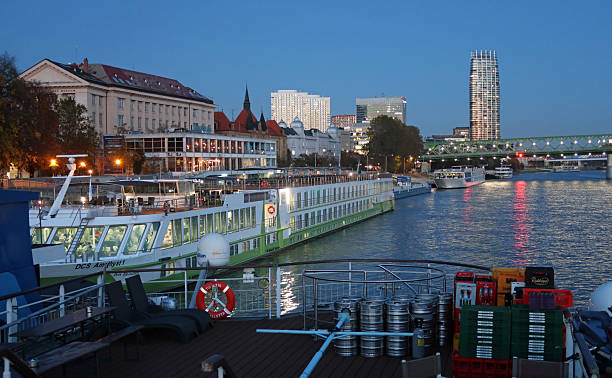 Bratislava, Slovakia, October 29, 2025. Illuminated Cruise ship moored on river Danube at the city waterfront. Dusk, twilight, evening autumn night outdoors