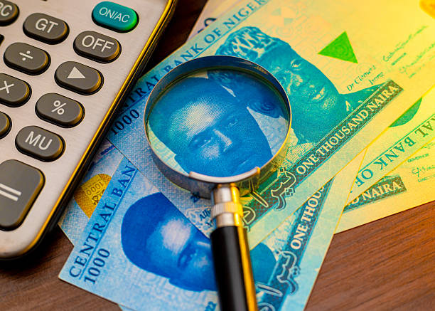 istock An image showing Nigerian 1,000 Naira notes under a magnifying glass, positioned next to a calculator. It depicts themes of finance, currency auditing, economic analysis, and monetary investigation. 2250318138